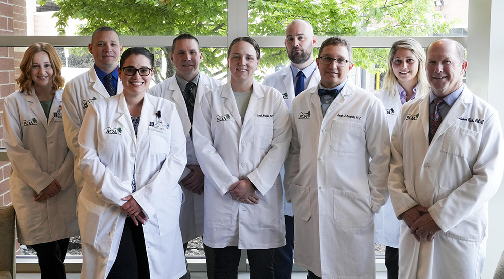 A photograph of Berkshire Orthopaedic Associate Physician Assistants standing in front of a window and smiling.